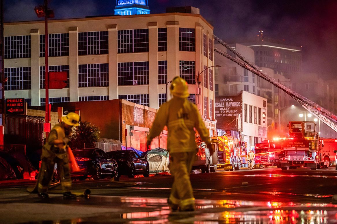 A firefighter drags a hose after <a href="https://www.cnn.com/2020/05/16/us/los-angeles-building-explosion-fire/index.html" target="_blank">an explosion in downtown Los Angeles</a> on Saturday, May 16. The blaze may have started at Smoke Tokes Wholesale Distributor — "reportedly a supplier for those who make butane honey oil," the Los Angeles Fire Department said. At least 11 firefighters were injured.