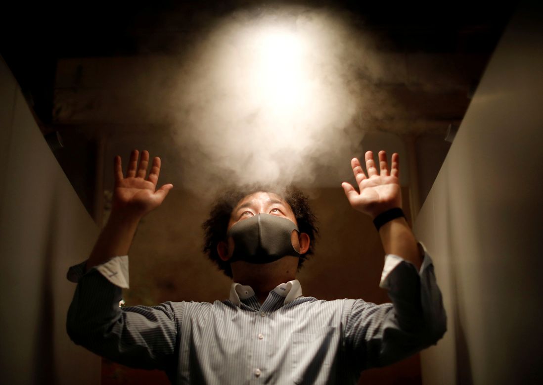 A man is sprayed with disinfectant at the entrance of a pub in Tokyo on Tuesday, May 19.