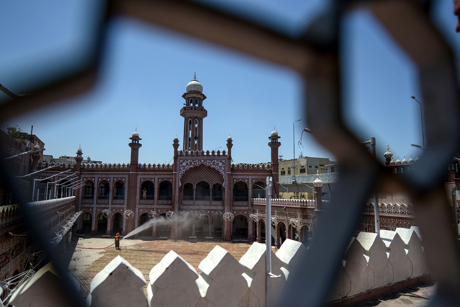 A worker sprays disinfectant in a mosque ahead of the last Friday prayers of the Muslim holy month of Ramadan in Peshawar, Pakistan, on May 21.