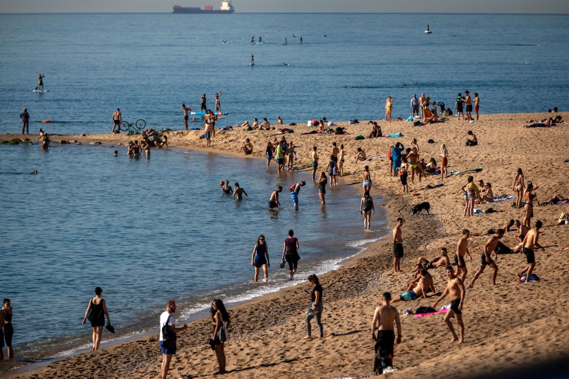 People enjoy the beach in Barcelona, Spain, Wednesday, May 20, 2020. Barcelona allowed people to walk on its beaches Wednesday, for the first time since the start of the coronavirus lockdown over two months ago. 