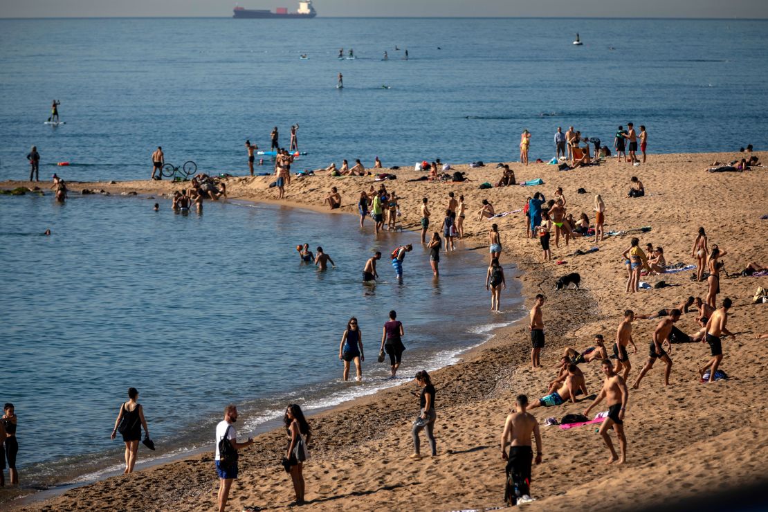 People enjoy the beach in Barcelona, Spain, Wednesday, May 20, 2020. Barcelona allowed people to walk on its beaches Wednesday, for the first time since the start of the coronavirus lockdown over two months ago.