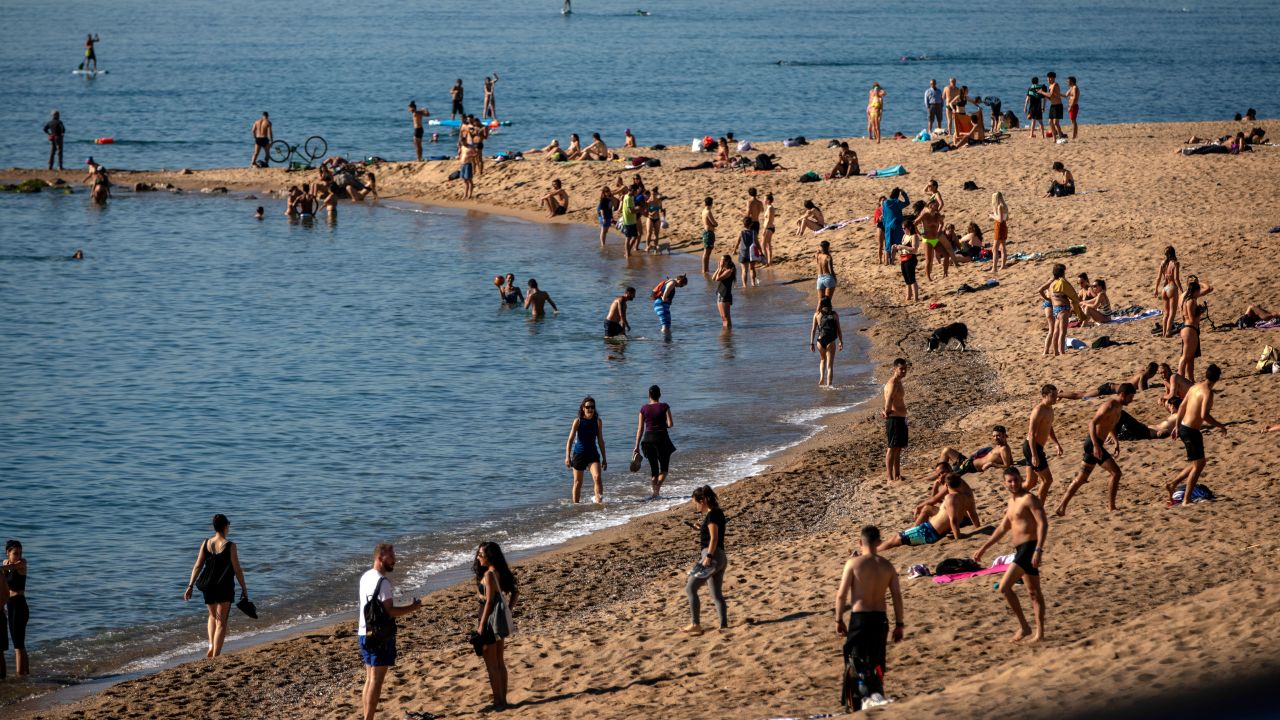 People enjoy the beach in Barcelona, Spain, Wednesday, May 20, 2020. Barcelona allowed people to walk on its beaches Wednesday, for the first time since the start of the coronavirus lockdown over two months ago. 