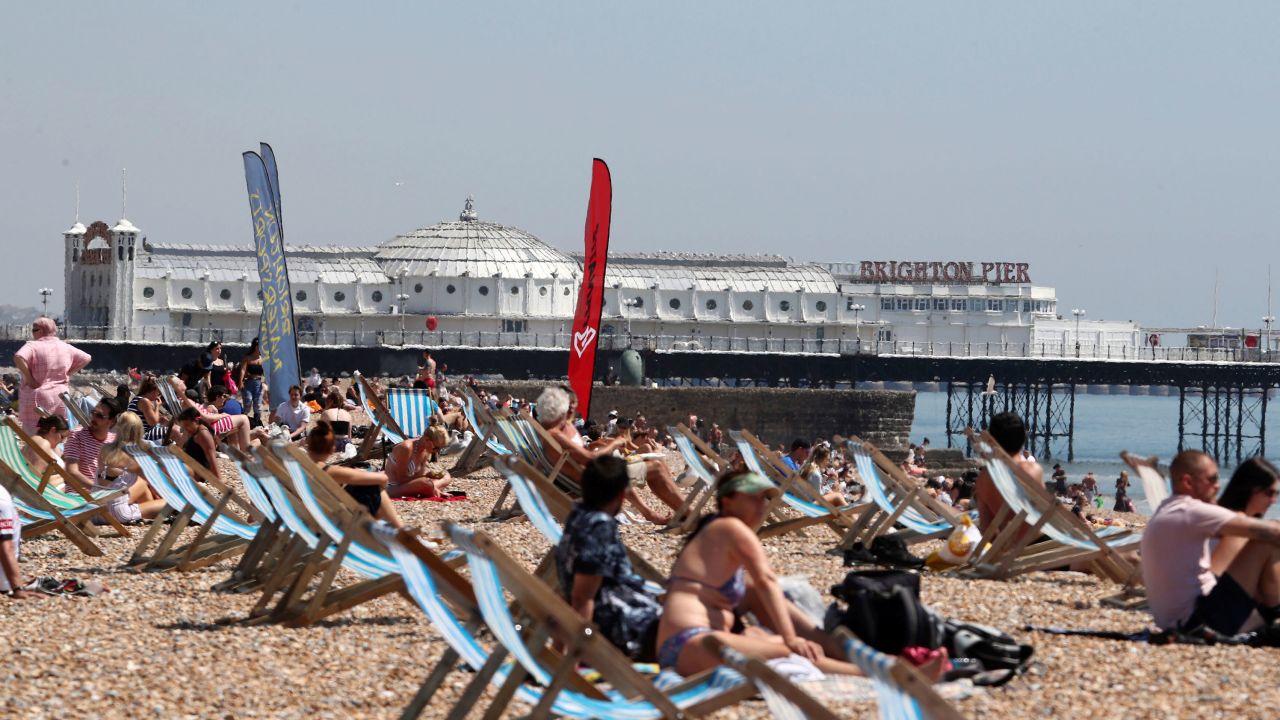 People enjoy the hot weather on the beach as lockdown measures due to the coronavirus outbreak were eased, in Brighton, England, Thursday May 21.