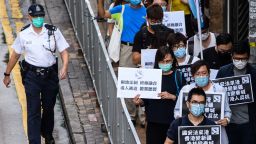 Pro-democracy protesters hold black placards that translate as "National Security Law comes to Hong Kong, Hong Kong becomes Xinjiang, Stanley Prison becomes Qincheng Prison, Hong Kongers Revolt", as they march towards the Chinese Liaison Office in Hong Kong on May 22, 2020. 