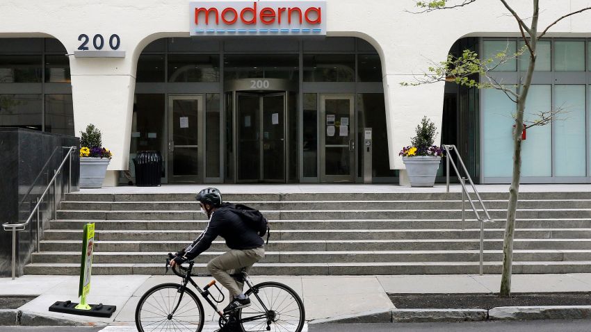 A bicyclists pedals past an entrance to a Moderna, Inc., building, Monday, May 18, 2020, in Cambridge, Mass. Moderna announced Monday that an experimental vaccine against the coronavirus showed encouraging results in very early testing, triggering hoped-for immune responses in eight healthy, middle-aged volunteers. (AP Photo/Bill Sikes)