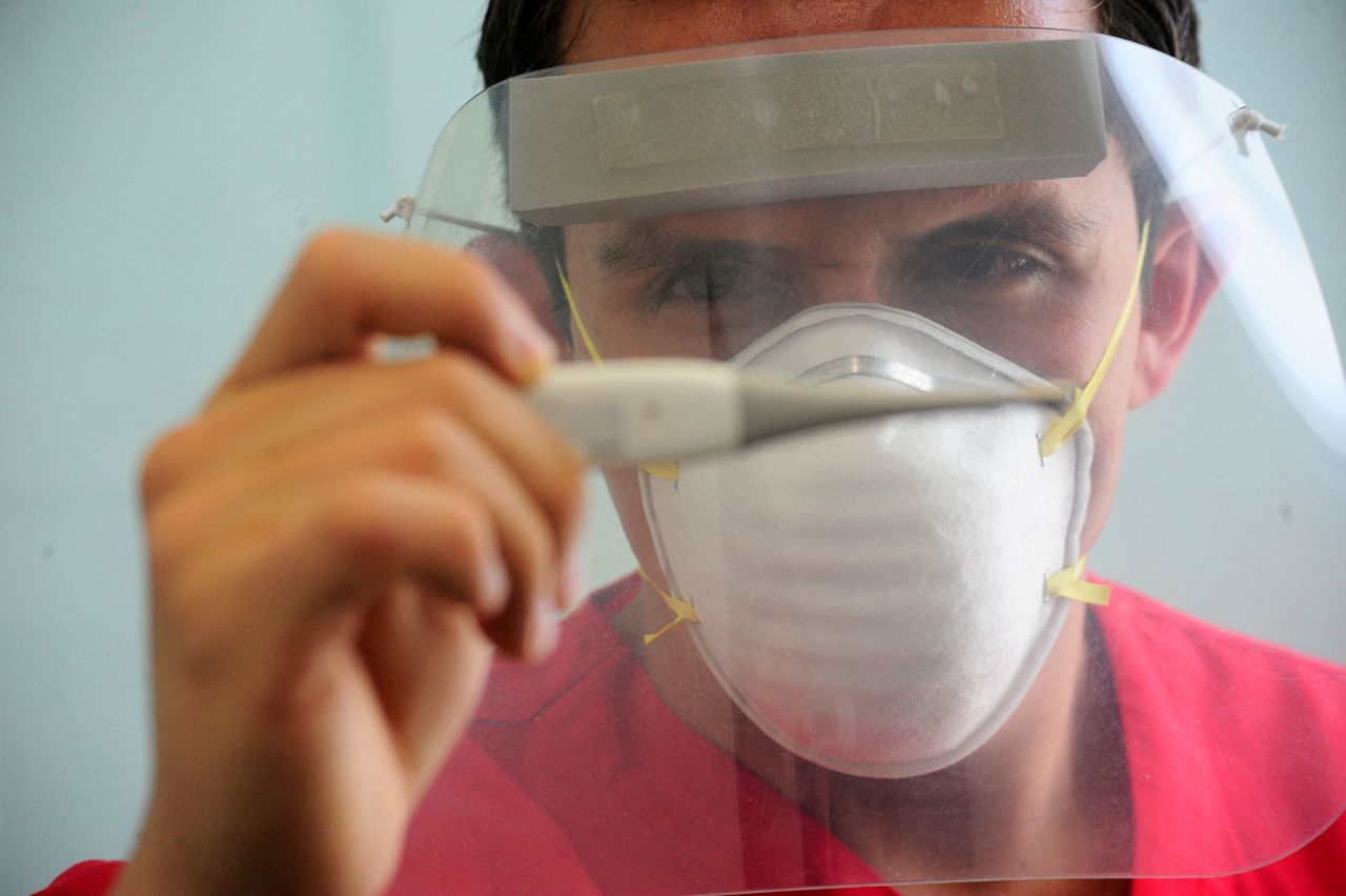 A health worker wears a face shield while checking a patient's temperature at a hospital in Toluca, Mexico, on May 21, 2020. Mexico had reported its highest number of new daily cases.