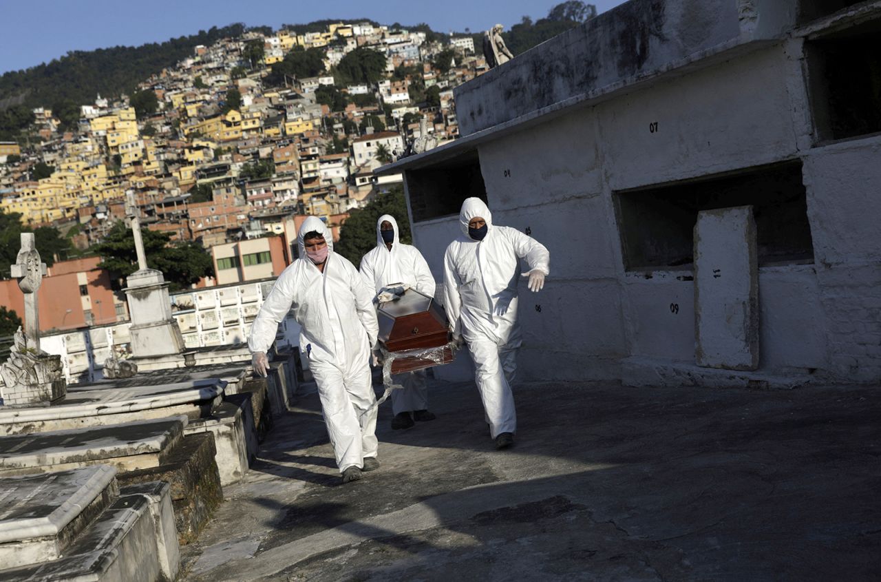 Gravediggers carry a coronavirus victim during his funeral in Rio de Janeiro on May 18.