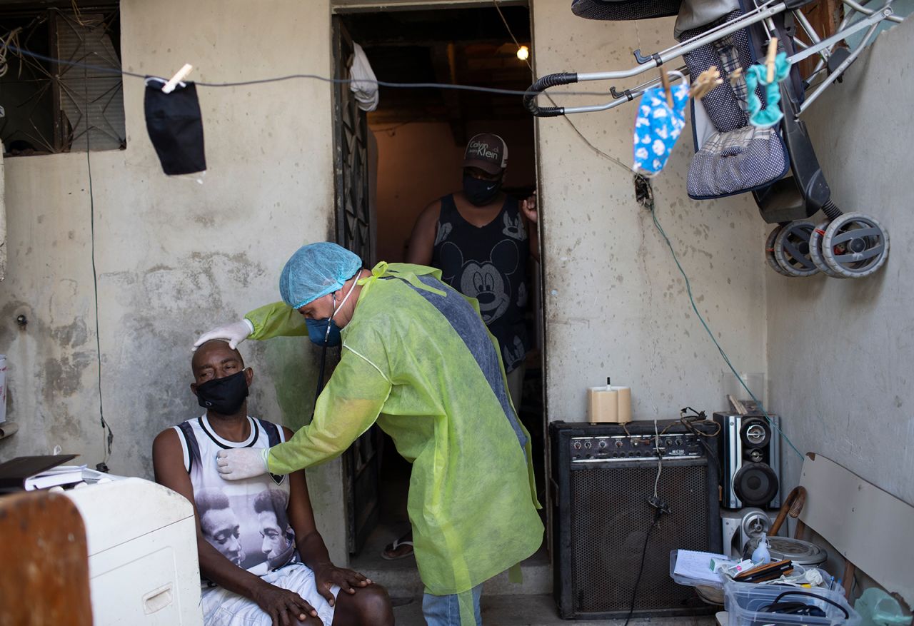 Dr. Willie Baracho checks out a patient in a Rio slum on May 19. Staying in isolation has been difficult for residents who live in tightly packed favelas and are forced to go to work in order to maintain an income.