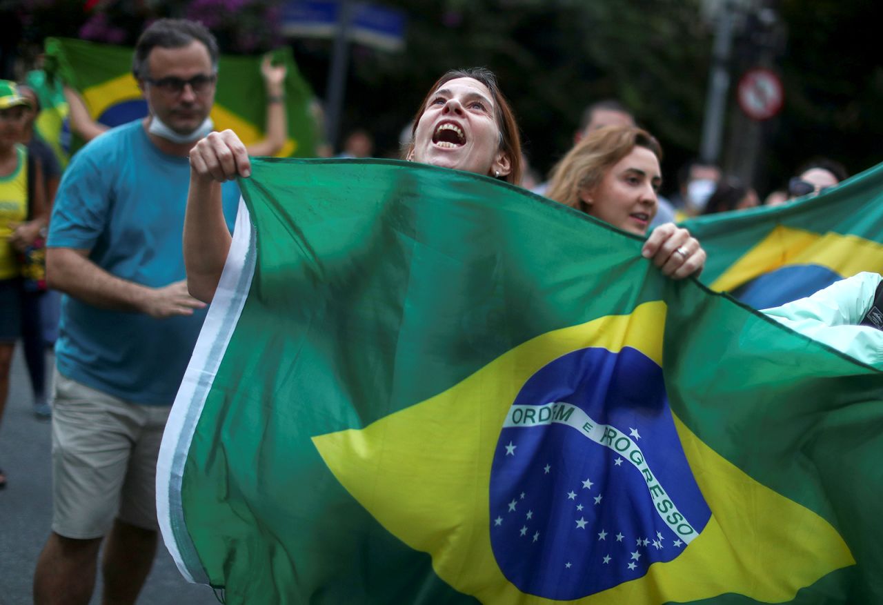 A woman holds a Brazilian flag while Bolsonaro supporters take part in a protest in front of the Chinese consulate in Rio on May 17. Protesters were blaming China for being the country where the coronavirus started.