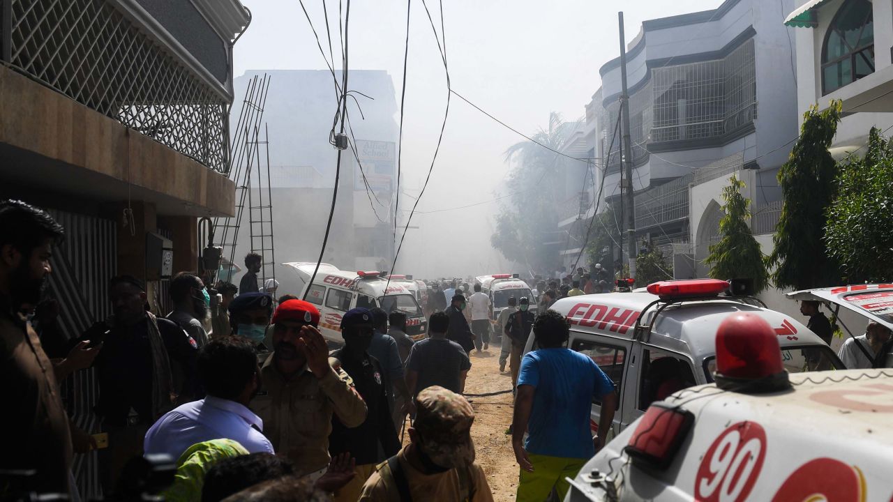 Rescue workers arrive at the site after a Pakistan International Airlines aircraft crashed at a residential area in Karachi on Friday.