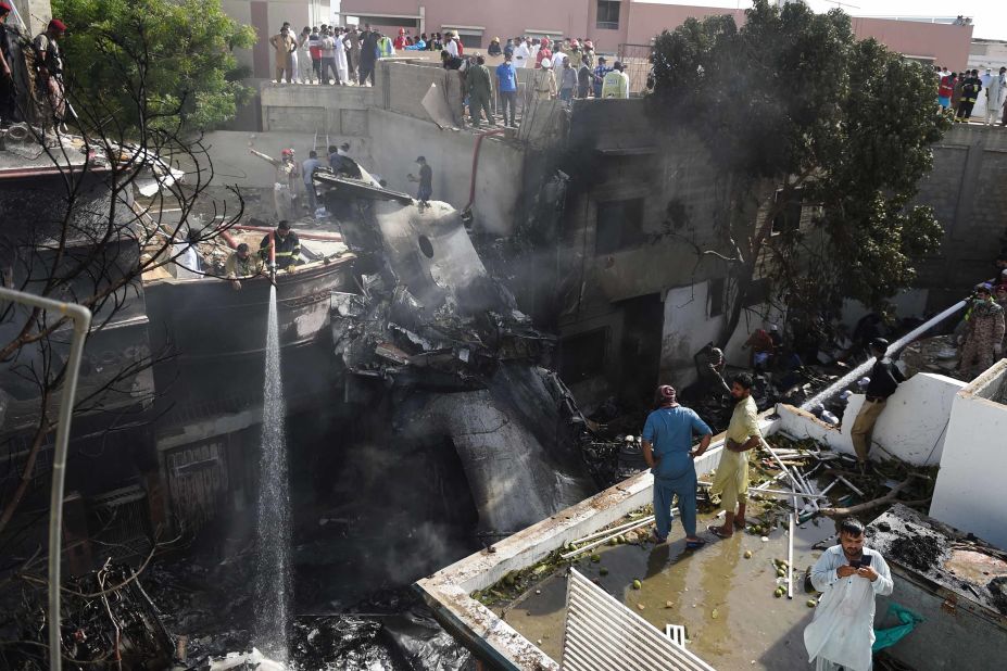 Firefighters spray water on the wreckage.