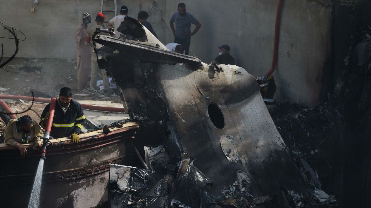 A firefighter sprays water on the wreckage of a Pakistan International Airlines aircraft after it crashed in a residential area in Karachi on Friday.
