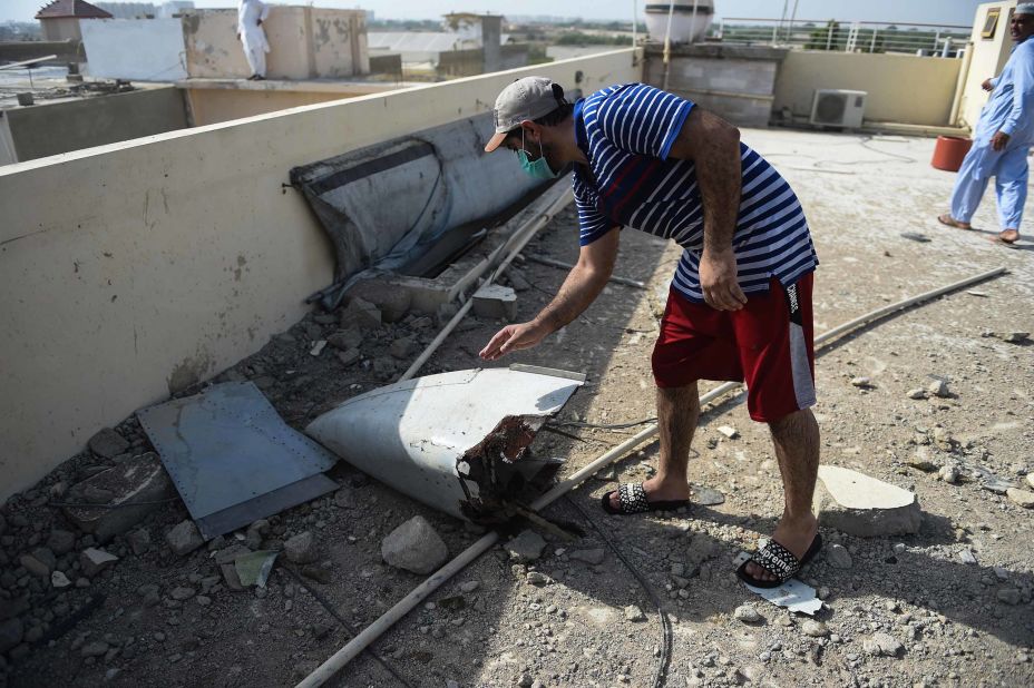 A man looks at a part of the plane's debris.