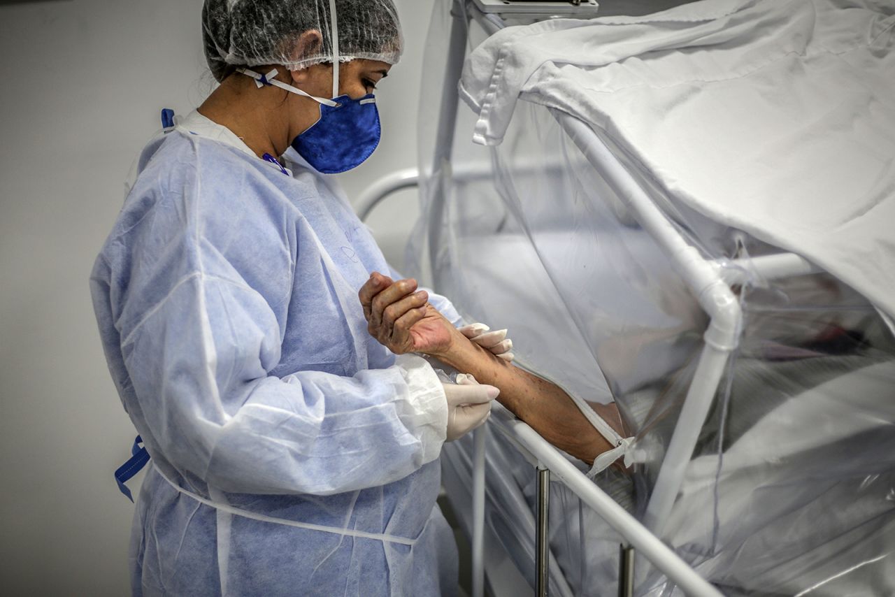 A nurse holds the arm of a coronavirus patient at a field hospital in Manaus on May 21. The hospital was built exclusively for coronavirus patients.