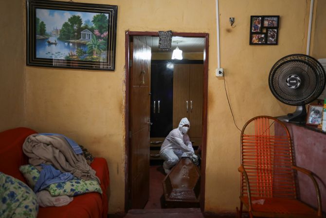 A funeral worker, wearing protective clothing, prepares to remove a coffin from a home in Manaus on May 7.