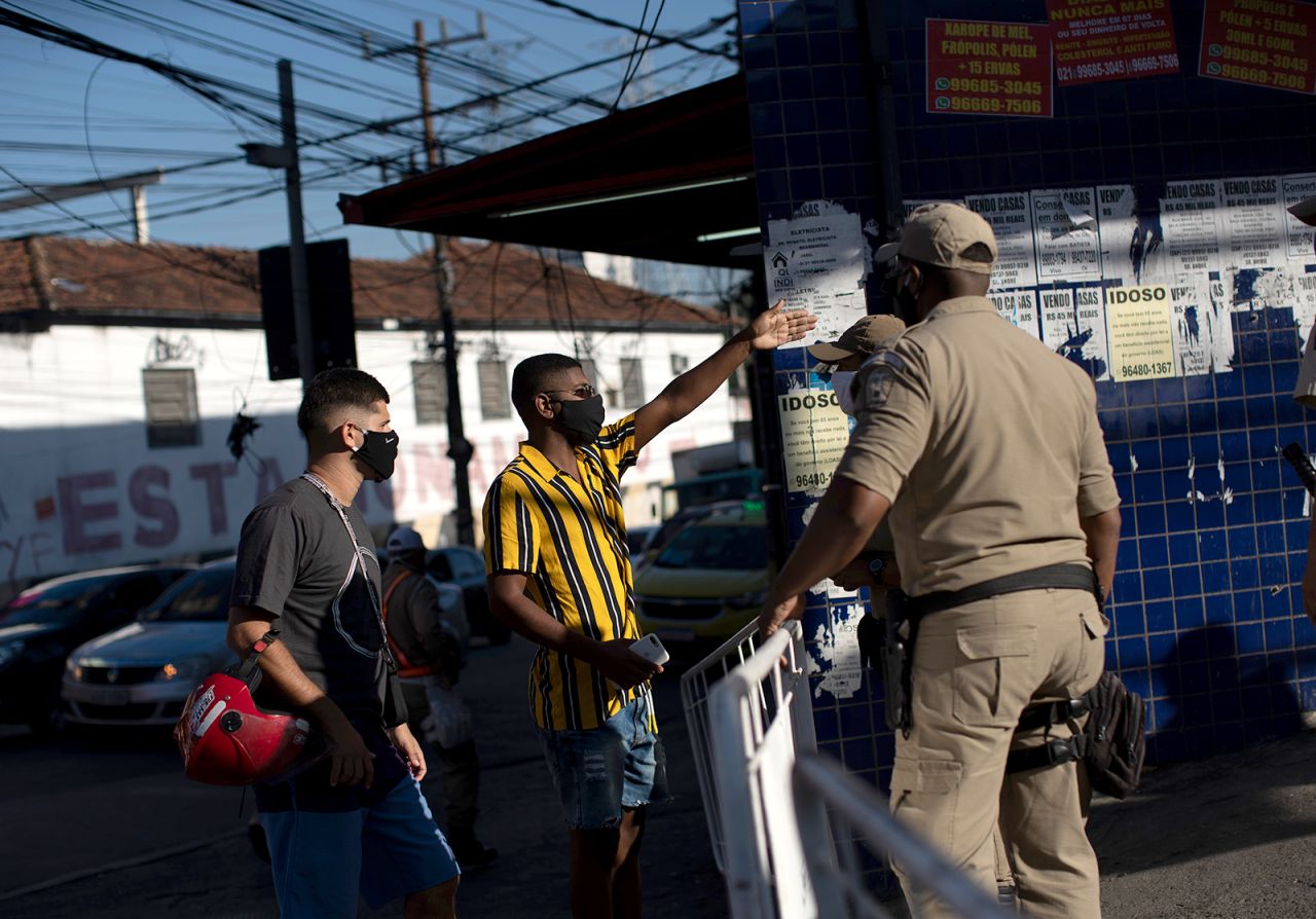 A municipal police officer asks a man for his documents at a checkpoint in Rio on May 12.