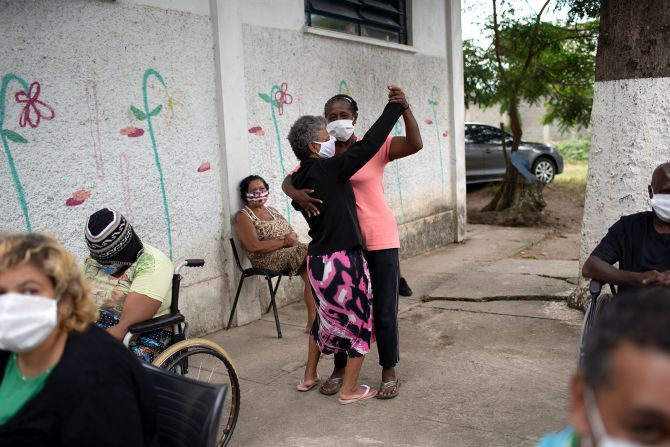 Women dance as an armed forces band plays at a Rio shelter for the elderly on May 14.