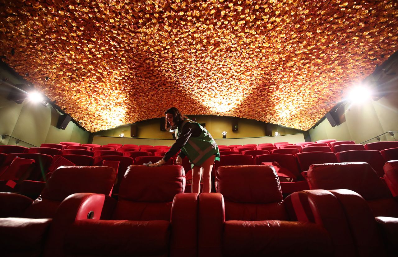 Jasmine Donaldson cleans a movie theater in Auckland, New Zealand, on May 22. Matakana Cinemas reopened May 28 with a reduced capacity to allow for social distancing between seats and in the foyer.
