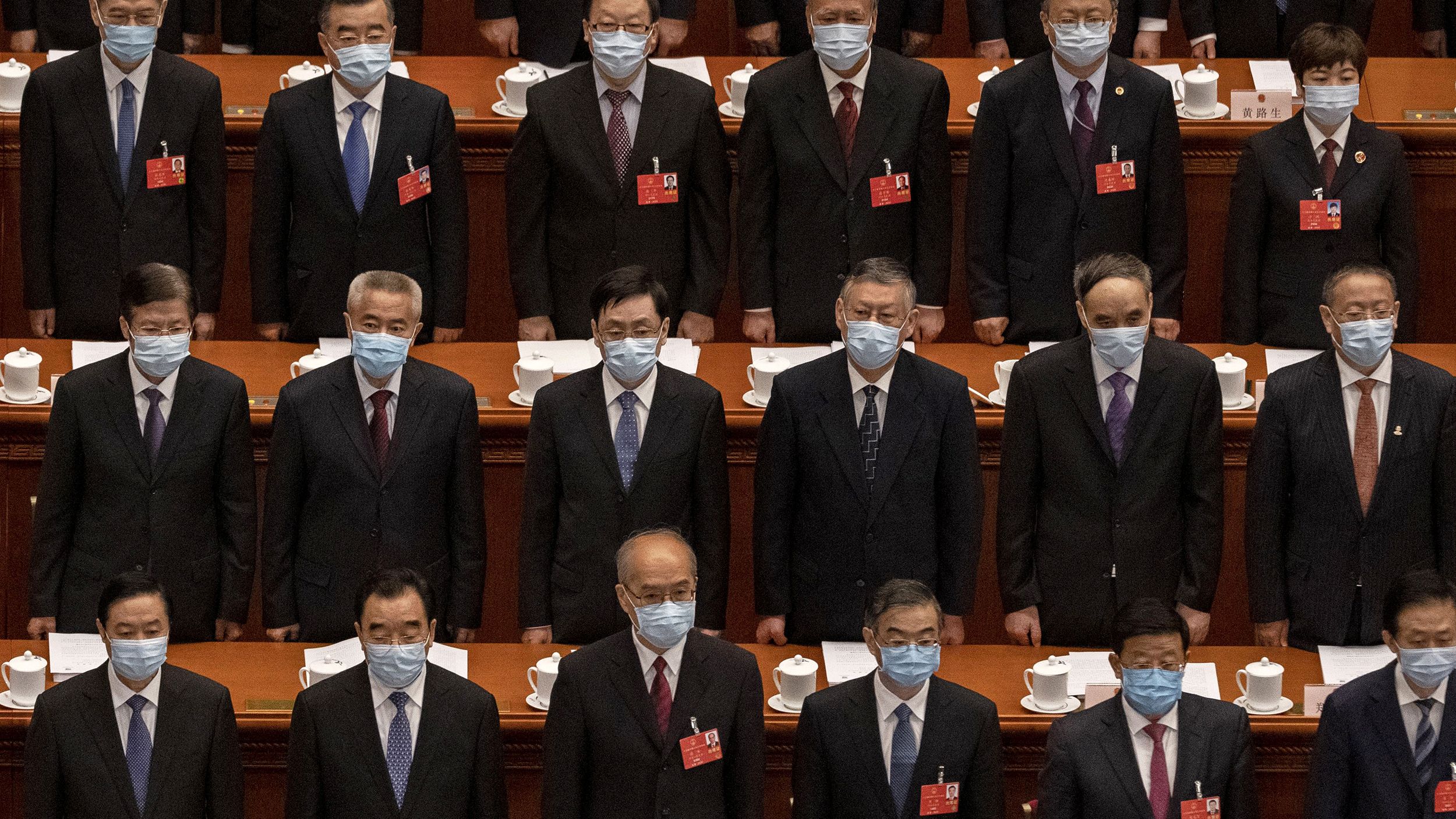 Chinese Communist Party delegates stand for the national anthem at the opening of the National People's Congress on May 22. The annual parliamentary gathering had been postponed.