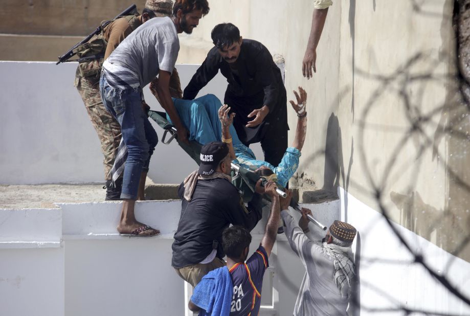 Rescuers transport an injured person from the site of the crash. The airliner came down in Model Colony, a busy residential area near Jinnah International Airport.