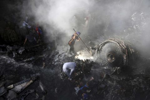 Volunteers look for survivors amid the wreckage of a plane crash in Karachi, Pakistan, on Friday, May 22.