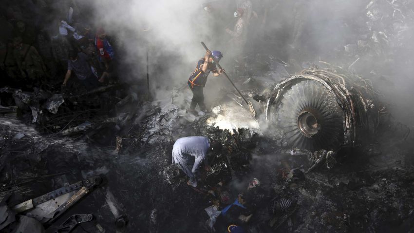 Volunteers look for survivors of a plane that crashed in a residential area of Karachi, Pakistan, May 22, 2020. An aviation official says a passenger plane belonging to state-run Pakistan International Airlines carrying more than 100 passengers and crew has crashed near the southern port city of Karachi. (AP Photo/Fareed Khan)