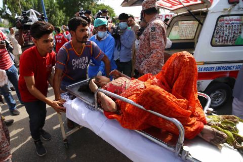 An injured woman is taken to a hospital in Karachi.