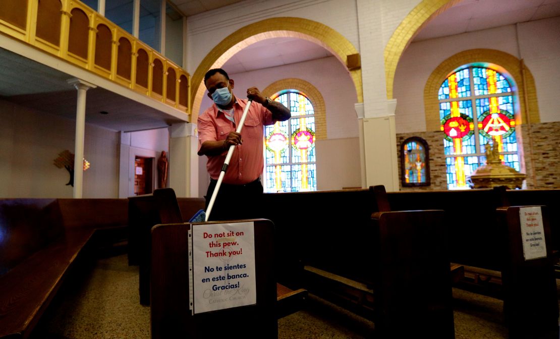 A man helps clean and sanitize pews following an in-person Mass at Christ the King Catholic Church in San Antonio on May 19.