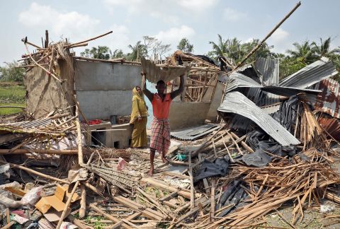 A man carries a tin sheet salvaged from the rubble of his damaged house in West Bengal, India, on Friday, May 22.