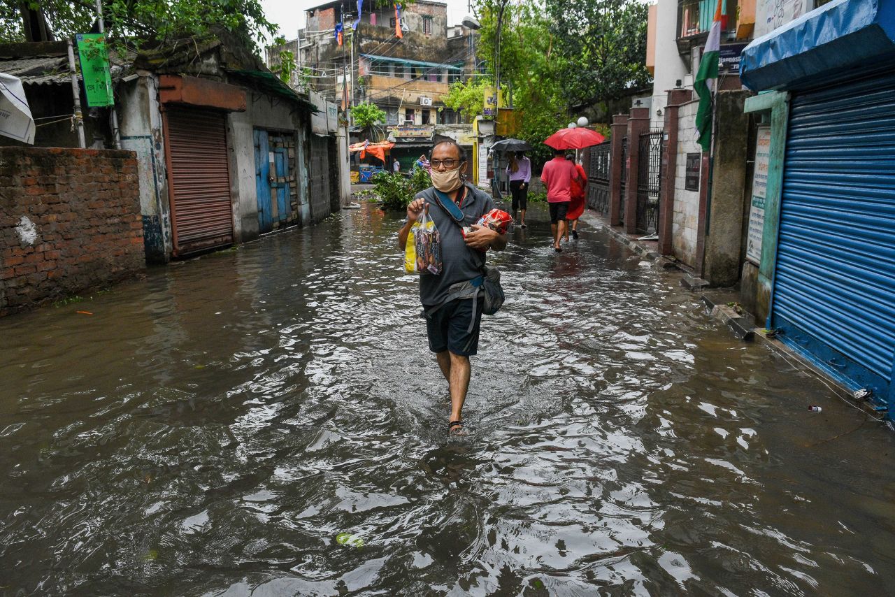 A man walks through a flooded street in Kolkata on May 21.