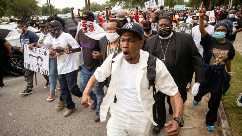Malik Muhammad, center, joins a group of people marching from the Glynn County Courthouse in downtown to a police station after a rally to protest the shooting of Ahmaud Arbery in Brunswick, Georgia, on May 16.