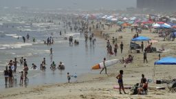 People gather on the beach for the Memorial Day weekend in Port Aransas, Texas, Saturday, May 23, 2020. Beachgoers are being urged to practice social distancing to guard against COVID-19. (AP Photo/Eric Gay)