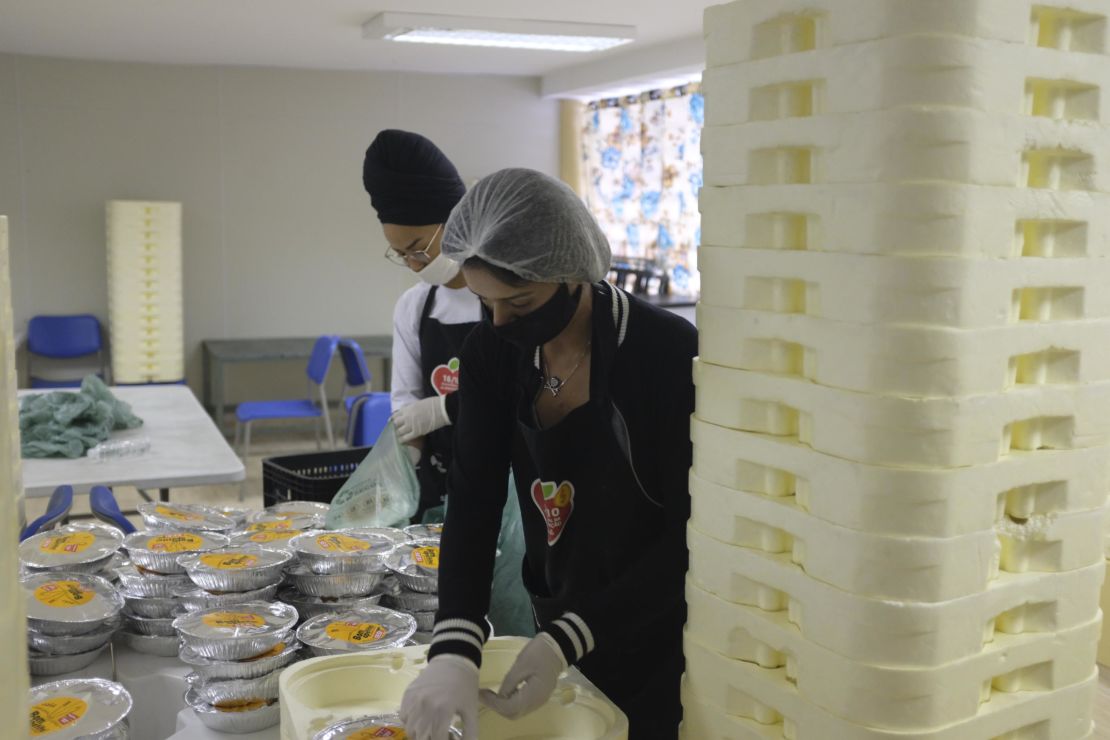 Volunteers prepare some of the 10,000 meals that are handed out to residents of the Paraisopolis favela each day, so they don't need to leave their houses to eat.
