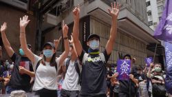 Protesters gesture with five fingers, signifying the "Five demands - not one less" as they march along a downtown street during a pro-democracy protest against Beijing's national security legislation in Hong Kong, Sunday, May 24, 2020. Hong Kong's pro-democracy camp has sharply criticised China's move to enact national security legislation in the semi-autonomous territory. They say it goes against the "one country, two systems" framework that promises the city freedoms not found on the mainland.