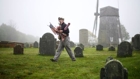 Brian Carabine, a retired US Marine, replaces flags at the South End Cemetery in East Hampton, New York, just before Memorial Day in 2020.