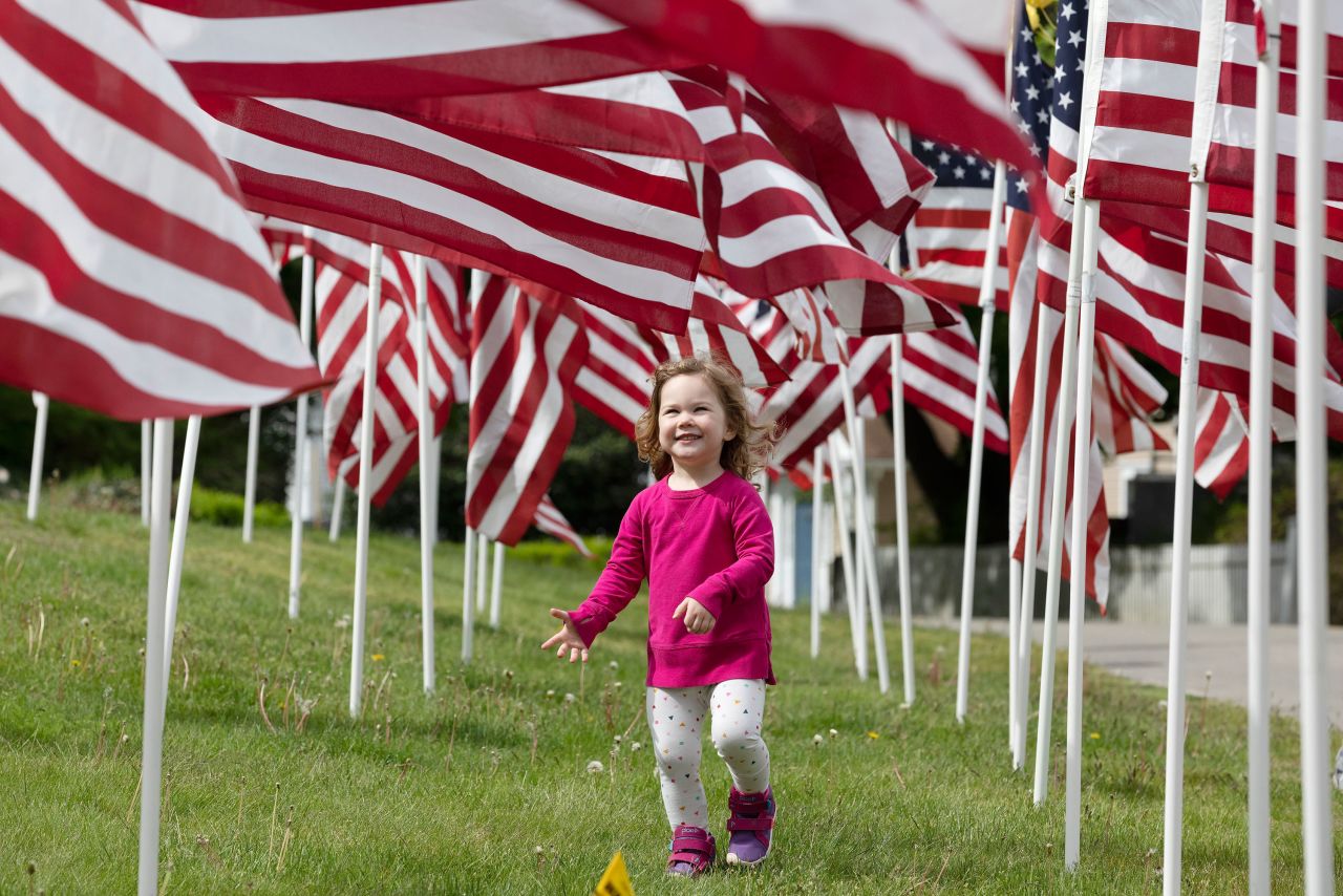 A child walks in a field of flags in Cohasset, Massachusetts, on Saturday.