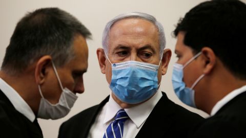 Prime Minister Benjamin Netanyahu stands with lawyers in Jerusalem's District Court on Sunday.