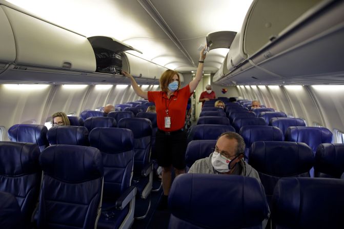 A Southwest Airlines flight attendant prepares a plane bound for Orlando, Florida, for takeoff from Kansas City on Sunday. Americans <a href="index.php?page=&url=https%3A%2F%2Fwww.cnn.com%2F2020%2F05%2F23%2Fbusiness%2Fair-travel-modest-rebound-memorial-day-weekend%2Findex.html" target="_blank">took a small and cautious step</a> to return to the skies this weekend, the start of the traditional summer travel season.