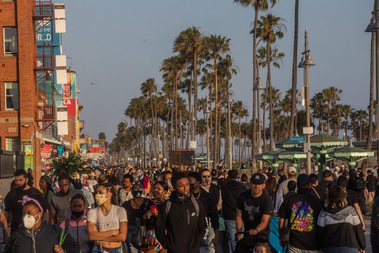 People walk along the boardwalk in Venice, California, on Saturday.