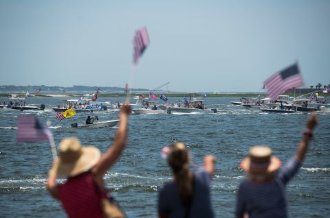 People wave American flags as boaters participate in a "Make America Great Again" parade in Charleston, South Carolina, on Sunday, May 24.
