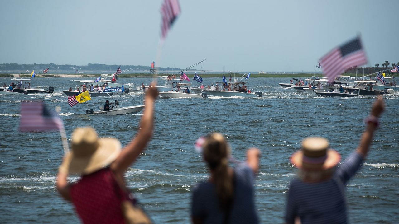 In this May 24, 2020, file photo, people wave American flags as boaters participate in the Make America Great Again parade in Charleston, South Carolina.