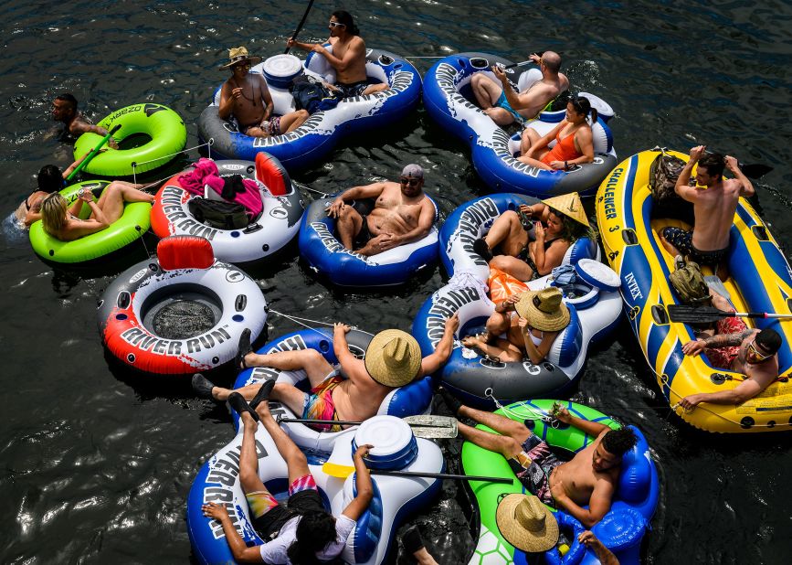 A group of people float on connected inflatables down the American River in the Sunrise Recreation Area near Rancho Cordova, California, on Sunday, May 24.