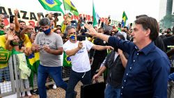 Brazil's President Jair Bolsonaro greets supporters upon arrival at Planalto Palace in Brasilia, on May 24, 2020, amid the COVID-19 coronavirus pandemic. - Despite positive signs elsewhere, the disease continued its surge in large parts of South America, with the death toll in Brazil passing 22,000 and infections topping 347,000, the world's second-highest caseload. (Photo by EVARISTO SA / AFP) (Photo by EVARISTO SA/AFP via Getty Images)