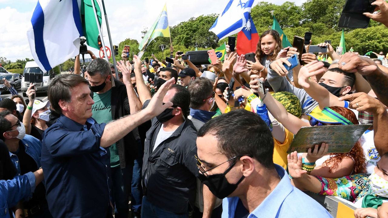 Brazil's President Jair Bolsonaro greets supporters upon arrival at Planalto Palace in Brasilia, on May 24.