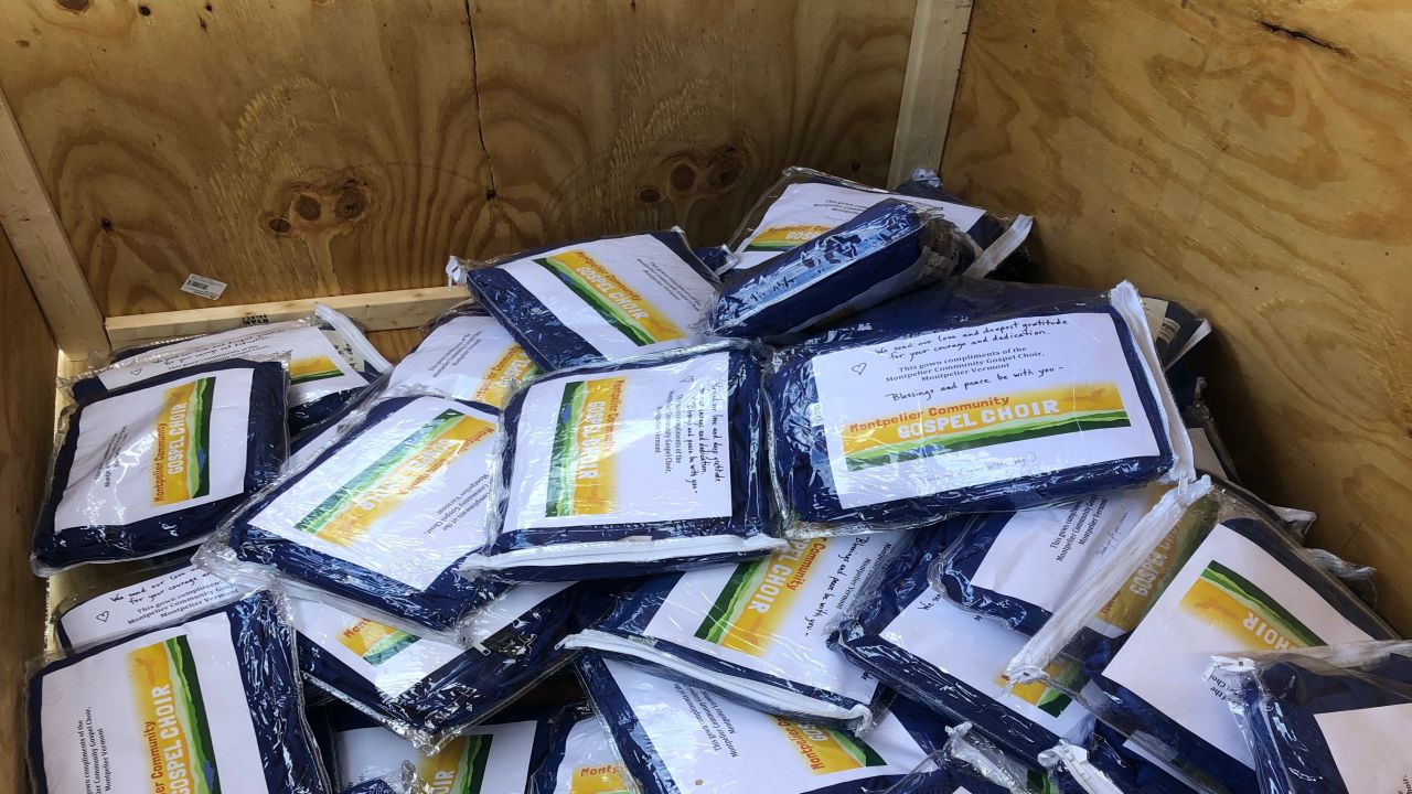 A donation bin shows dozens of gowns dropped off by locals.