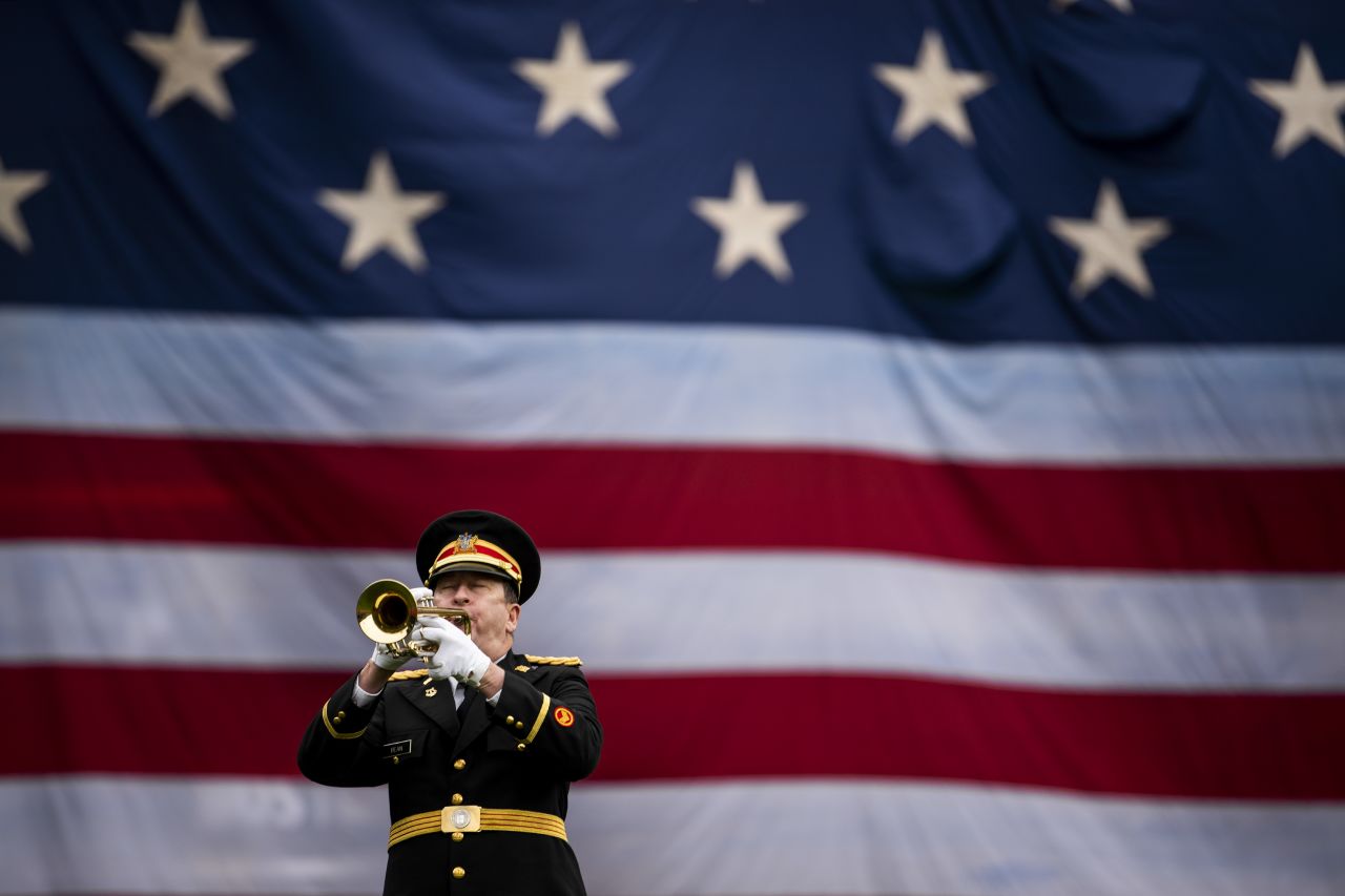 Robert Bean, a retired member of the US Marine Corps and National Guard, plays taps as the American flag is lowered over the Green Monster at Fenway Park in Boston on Monday.