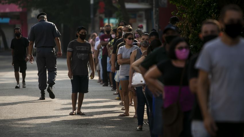 RIO DE JANEIRO, BRAZIL - MAY 18: People wearing protective masks wait in line while respecting social distancing rules outside a Caixa Economica Federal bank branch in Bonsucesso neighborhood to receive the second installment of the urgent government benefit amidst the coronavirus (COVID-19) pandemic on May 18, 2020 in Rio de Janeiro, Brazil. The benefit is directed at informal workers, small individual business owners, self-employed workers, and unemployed people under vulnerability, and it has been granted as part of the efforts to tackle the coronavirus (COVID-19) pandemic. According to the Brazilian Health Ministry, Brazil has over 240,000 positive cases of coronavirus (COVID-19) and more than 16,000 deaths. (Photo by Bruna Prado/Getty Images)