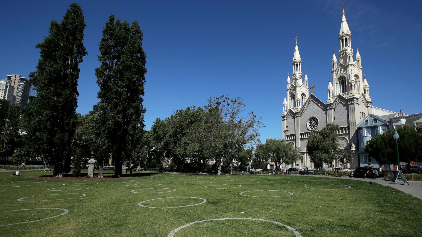 Circles designed to help prevent the spread of the coronavirus by encouraging social distancing are shown at a park in front of Saints Peter and Paul Church in San Francisco, California.