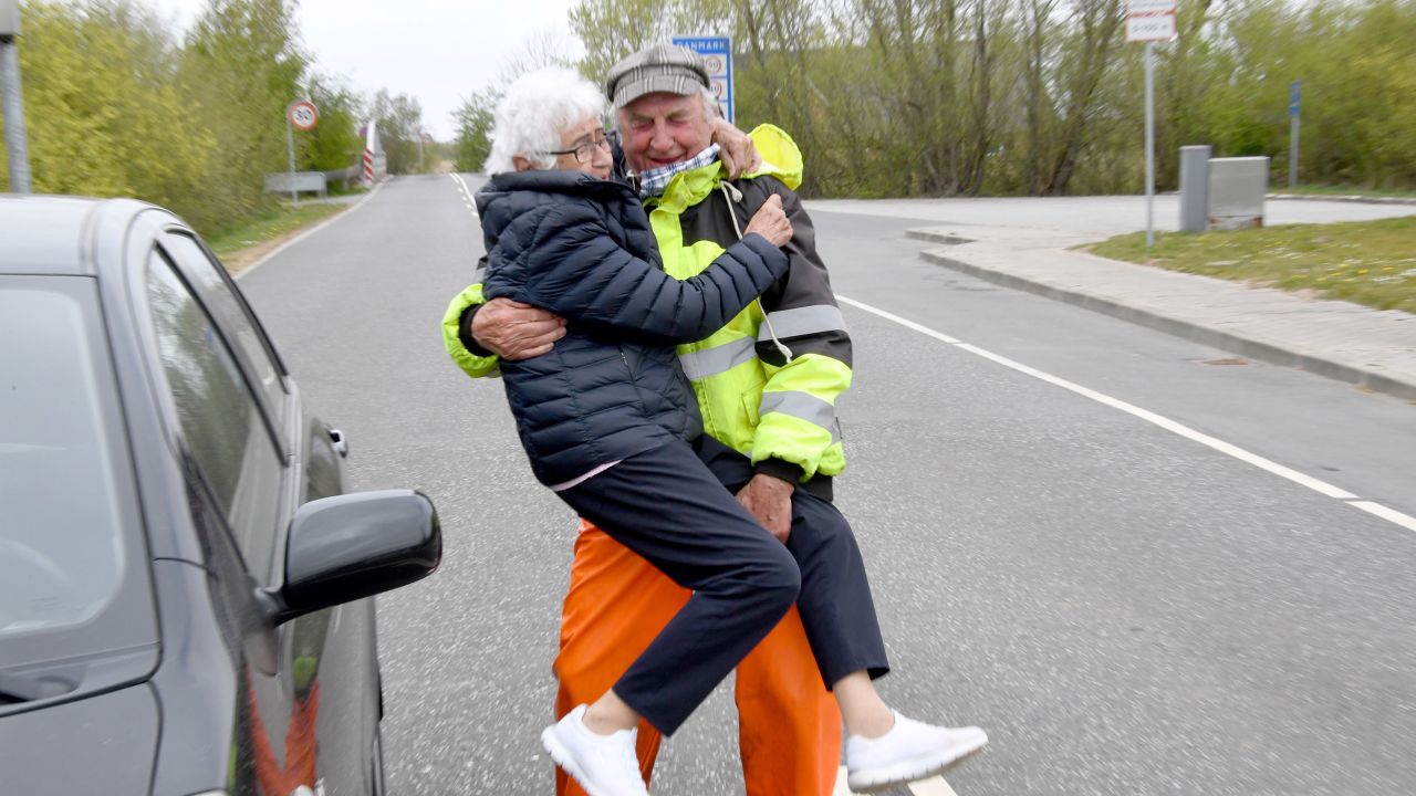 Inga Rasmussen, left, from Denmark is lifted up by Karsten Tüchsen Hansen from North Frisia, Germany, during their daily meeting at the German-Danish border on April 24.