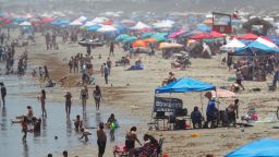 People gather on the beach for the Memorial Day weekend in Port Aransas, Texas, Saturday, May 23, 2020. Beachgoers are being urged to practice social distancing to guard against COVID-19. (AP Photo/Eric Gay)